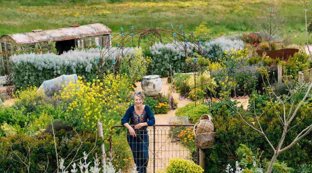 woman leaning on gate in garden